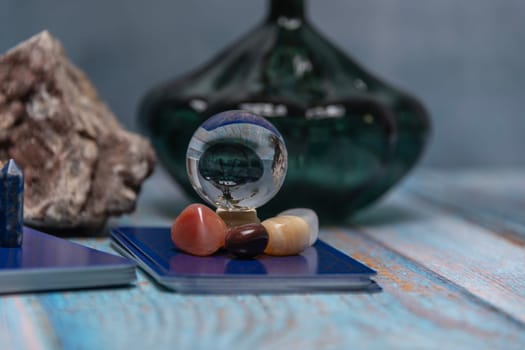An intimate tarot reading session arrangement featuring vibrant crystals, tarot cards, and a geode on a rustic wooden table