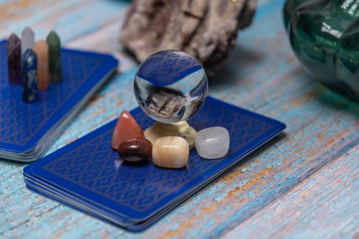 A tarot card reading setup with an array of colorful healing crystals on a weathered wooden table, invoking a sense of mysticism