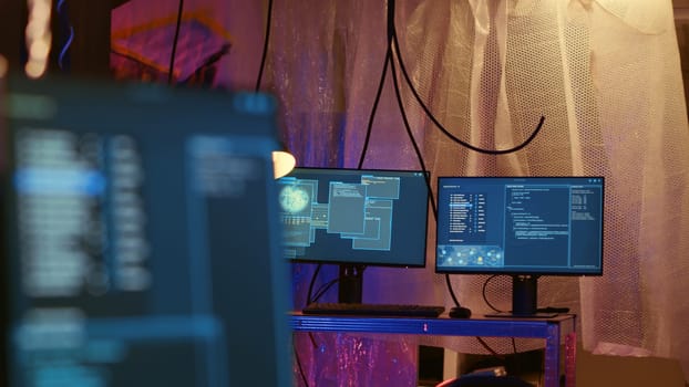 Empty abandoned underground warehouse with lines of code running on computer screen with malware that get past security systems. Monitors in hidden HQ showing scripts that can hack devices