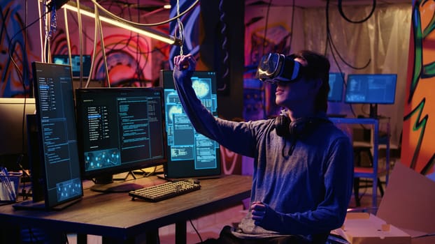 Hacker using virtual reality goggles technology to steal sensitive data by taking advantage of security breaches. Cybercriminal in hidden base using VR headset to gain unauthorized access to systems