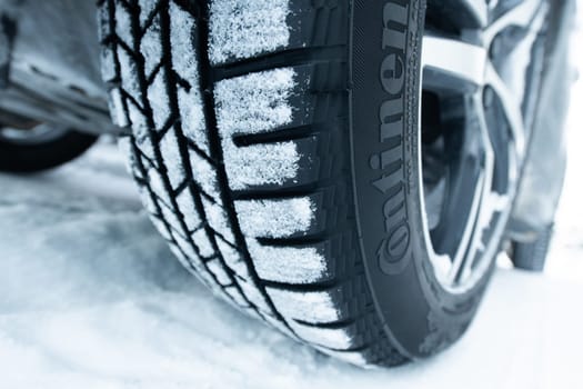 A close-up photograph of a winter tire on a car
