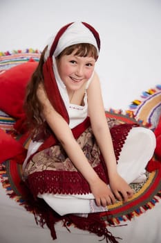 Portrait of Little girl in a stylized Tatar national costume on a white background in the studio. Photo shoot of funny young teenager who is not a professional model