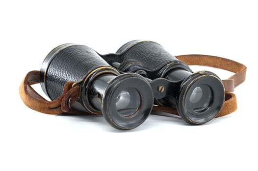 Ancient pair of black binoculars with brown leather straps isolated on white background