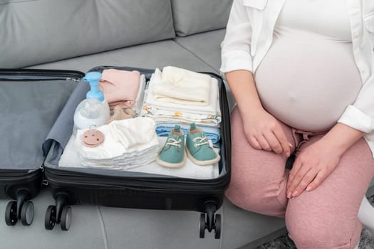 Suitcase with folded things for maternity hospital in pregnant woman's suitcase.