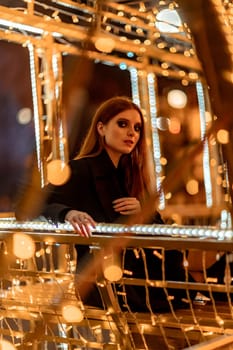 Christmas mood. Woman with long hair in sity decorated for Christmas. She is dressed in a black coat