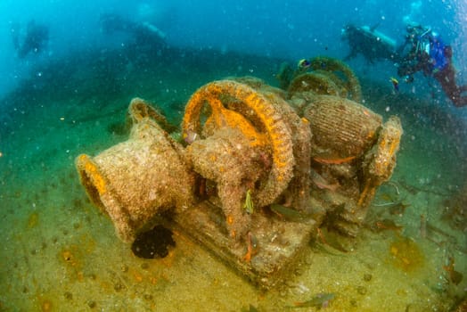 scuba divers exploring a shipwreck underwater