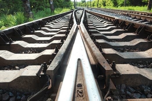 Railway tracks with switches and interchanges with geometrical structures, thresholds, gravel and screws. Reflecting symmetrical rails download