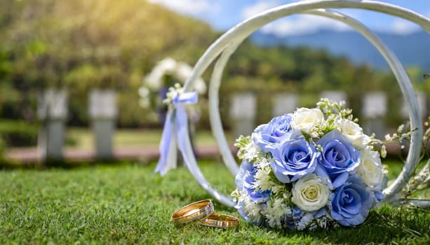 Wedding nature background with blue roses, gold rings and white decoration. High quality photo