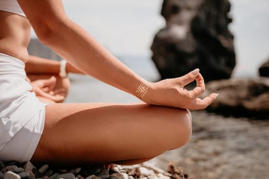 Woman sea yoga. Back view of free calm happy satisfied woman with long hair standing on top rock with yoga position against of sky by the sea. Healthy lifestyle outdoors in nature, fitness concept.