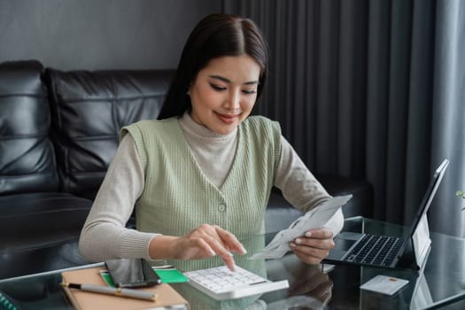 young woman calculating monthly home expenses, tax, bank account balance and credit card bills payment.