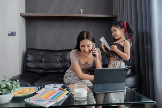 business woman work from home and take care of her child while working, doing activities with her child while working.