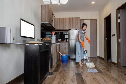 Asian woman cleaning house during weekend, sweeping floor house. cleaning day concept.