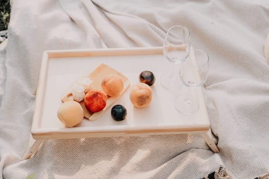 Picnic and wine tasting at sunset in the hills of Italy, Tuscany. Vineyards and open nature in the summer. Romantic dinner, fruit and wine.