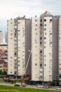 Home removal with hydraulic lift. Transporters carrying goods by elevator from the window of the building