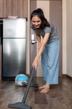 Young woman asian cleaning floor with vacuum cleaner in living room, Housework, cleanig and chores concept.