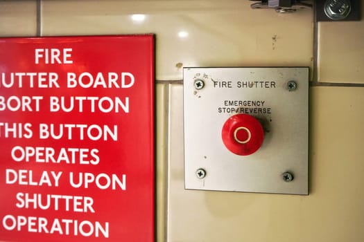 London, United Kingdom - February 02, 2019: Emergency fire shutter button at underground train station wall, with instructions on red panel written left side
