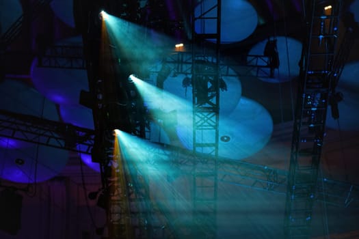 Blue reflector lights shining through smoke on theatre roof before performance