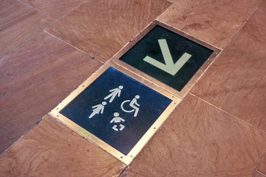 Toilets and baby changing room sign with arrow symbol on the floor of shopping mall