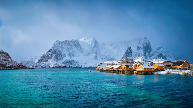 Panorama of yellow rorbu houses of Sakrisoy fishing village with snow in winter. Lofoten islands, Norway