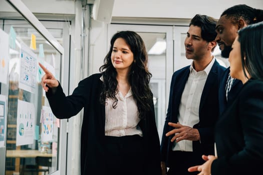 In a meeting setting, professionals creatively brainstorm and strategize on a transparent glass board. Teamwork, collaboration, and leadership are key to their success.