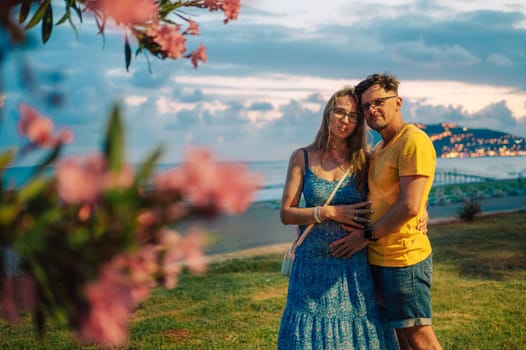 Happy couple taking a photo on a beach at the sea in Alanya city, Turkey. Focus on the background. Travelling or vacation concept