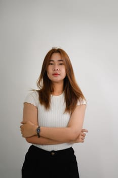 Portrait of pretty young Asian woman posing against white background.