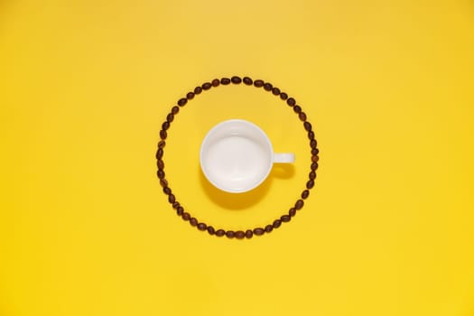 Empty coffee cup and coffee beans on yellow background.