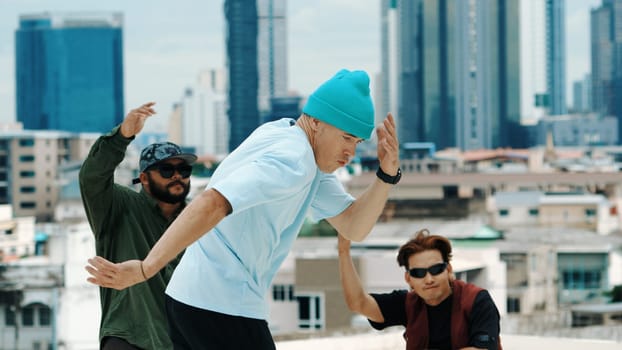 Professional break dance team practice B-boy dance while multicultural friends at rooftop. Young modern dancing group doing hip hop movement. Style,fashion,action. Outdoor sport 2024. Endeavor.