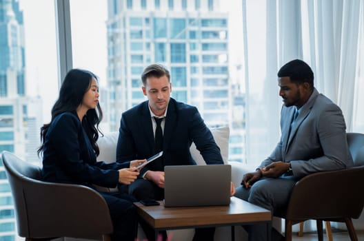 Young smart businesswoman showing data analysis to diverse investor by using tablet. Multicultural business group discussing and investing in start up project. Modern office. Meeting. Ornamented.