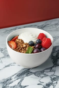 a bowl of yogurt and berries on the table. The concept of healthy food.