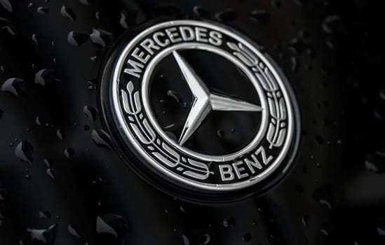 Chernigov Ukraine 13.03.2024-Close-up of the blue round Mercedes Benz logo on the hood of a black car 3