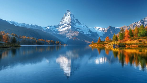 A majestic mountain is mirrored in the tranquil waters of a lake, with snowy peaks, lush trees, and a clear blue sky completing the natural landscape