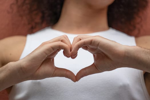 Man showing hand sign heart on his chest.Man making a heart shape with his hands.