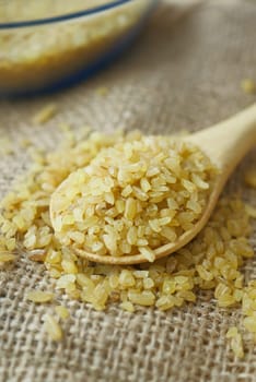 Raw Bulgur Rice on wooden spoon