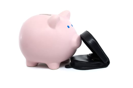 Pink piggy bank alongside a black wallet which is open showing some bills, isolated on a white background