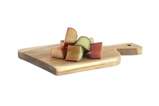 Variety of rhubarb stalks of varying colors from pale green to deep red on wooden cutting board isolated on white background