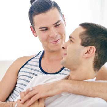 Men, gay and couple or hug in apartment resting with lgbt pride or comfortable love, happiness or connection. Male person, queer and smile with bonding for partnership in home together, calm or peace.