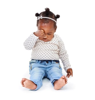 Child, tired and rubbing eyes in studio while sleepy from playing, learning and motor development in white background. Baby girl or infant, sitting and drowsy or sleeping for nap time, rest and peace.