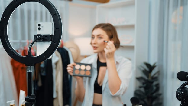 Woman influencer shoot live streaming vlog video review makeup prim social media or blog. Happy young girl with cosmetics studio lighting for marketing recording session broadcasting online.