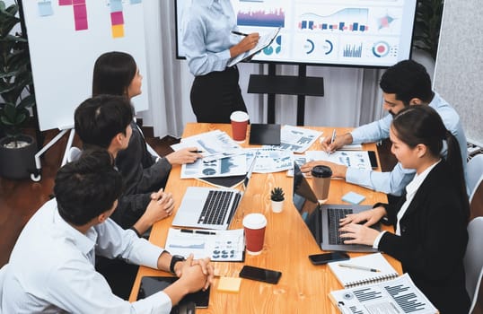 Young african businesswoman presenting data analysis dashboard on TV screen in modern meeting. Business presentation with group of business people in conference room. Concord