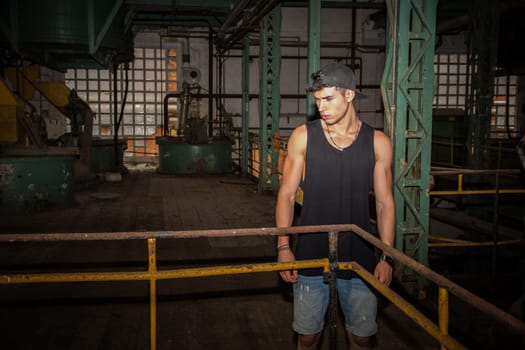 A man in a tank top standing in a factory