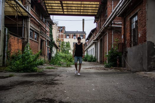 A man in a tank top standing in a factory