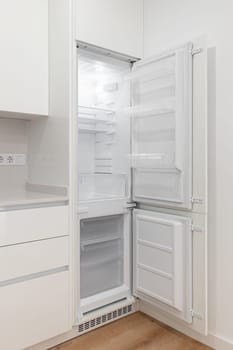 A white refrigerator freezer sitting inside of a kitchen