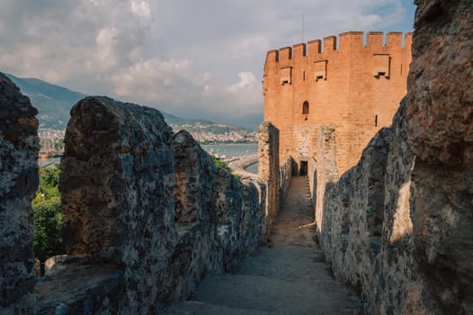 Fortress ruins of the historical Red Tower - Kizil Kule, in Alanya Castle. The Red Tower is the symbol of the Alanya city, and the famous touristic place, Turkey (Turkiye).