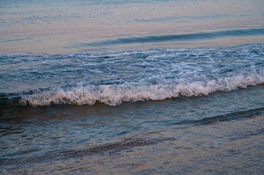 Waves of Mediterranean Sea rolling to the sandy Turkish beach. Beautiful Turkish evening.