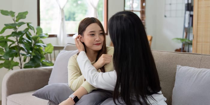 Loving LGBTQIA lesbian gay couple laughing together in Livingroom. Asian LGBTQIA lesbian gay couple laughed happy together while sitting on the sofa. Homosexual-LGBTQ concept..