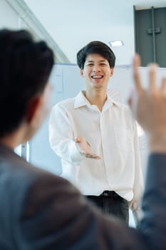 Young Business answering a colleague question during a presentation in boarding room.