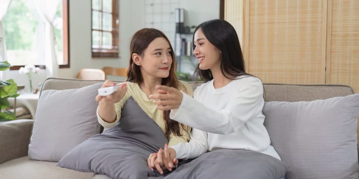 Asian lesbian woman couple enjoy watch TV together in house and feel happy watch movie on television. Homosexual-LGBTQ concept..