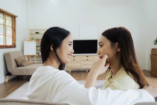 Asian lesbian woman couple enjoy watch TV together in house and feel happy watch movie on television. Homosexual-LGBTQ concept..