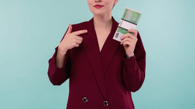 Portrait of beautiful young businesswoman pointing finger at money , on blue background - Image